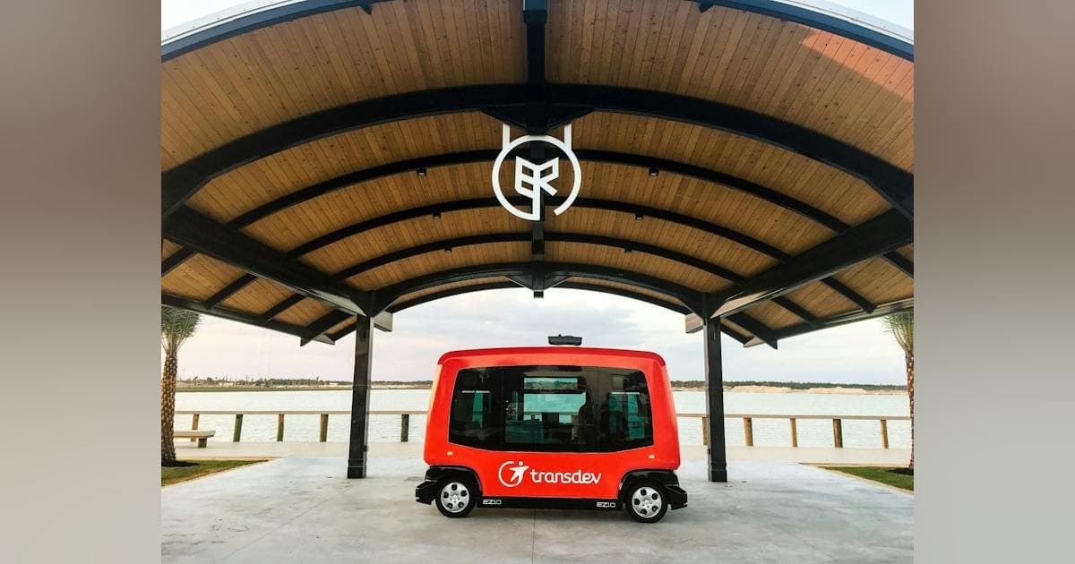 Red Transdev autonomous shuttle at Babcock Ranch's waterfront pavilion